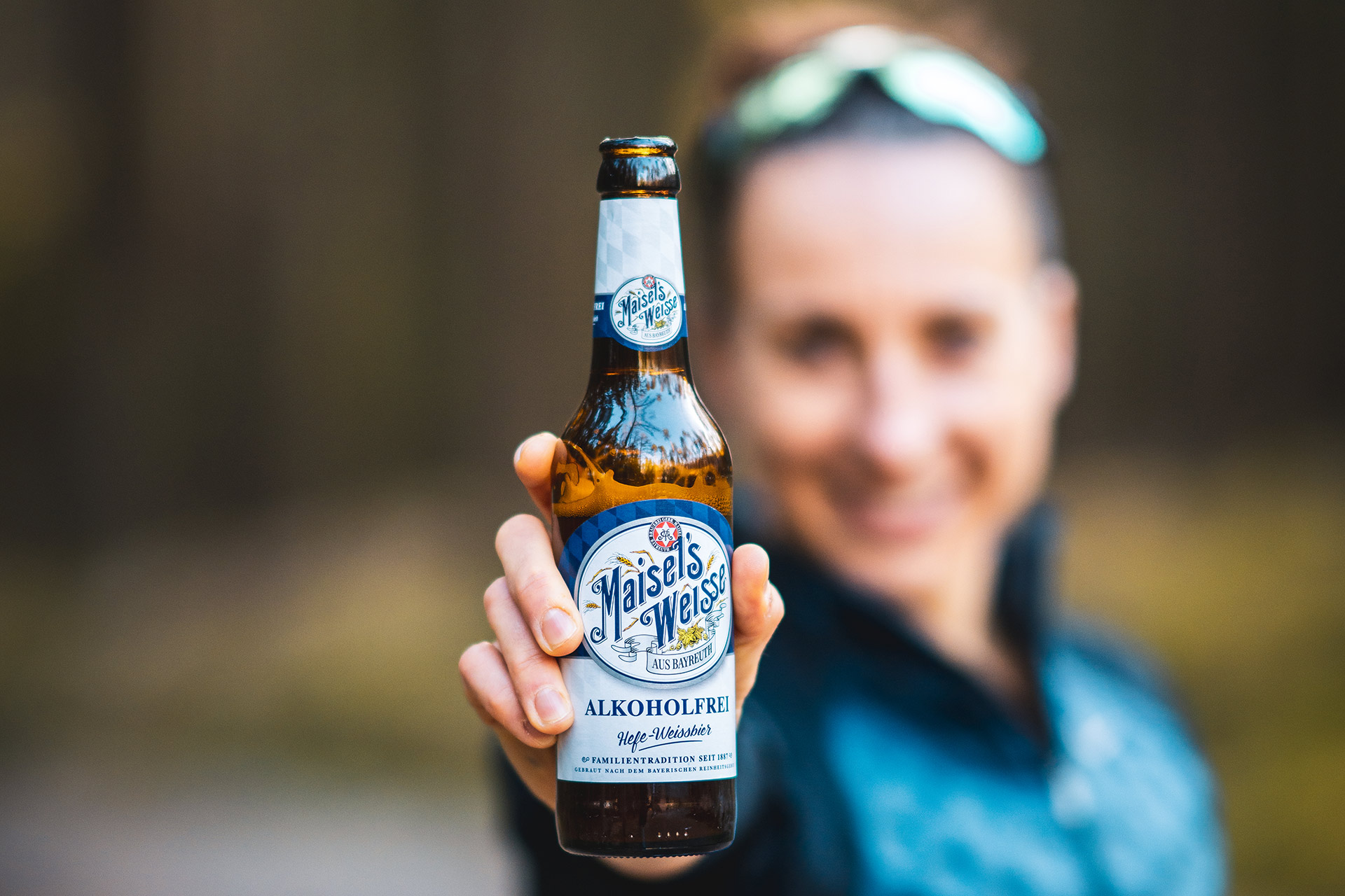 Läuferin hält Maisel's Weisse Akoholfrei in die Kamera